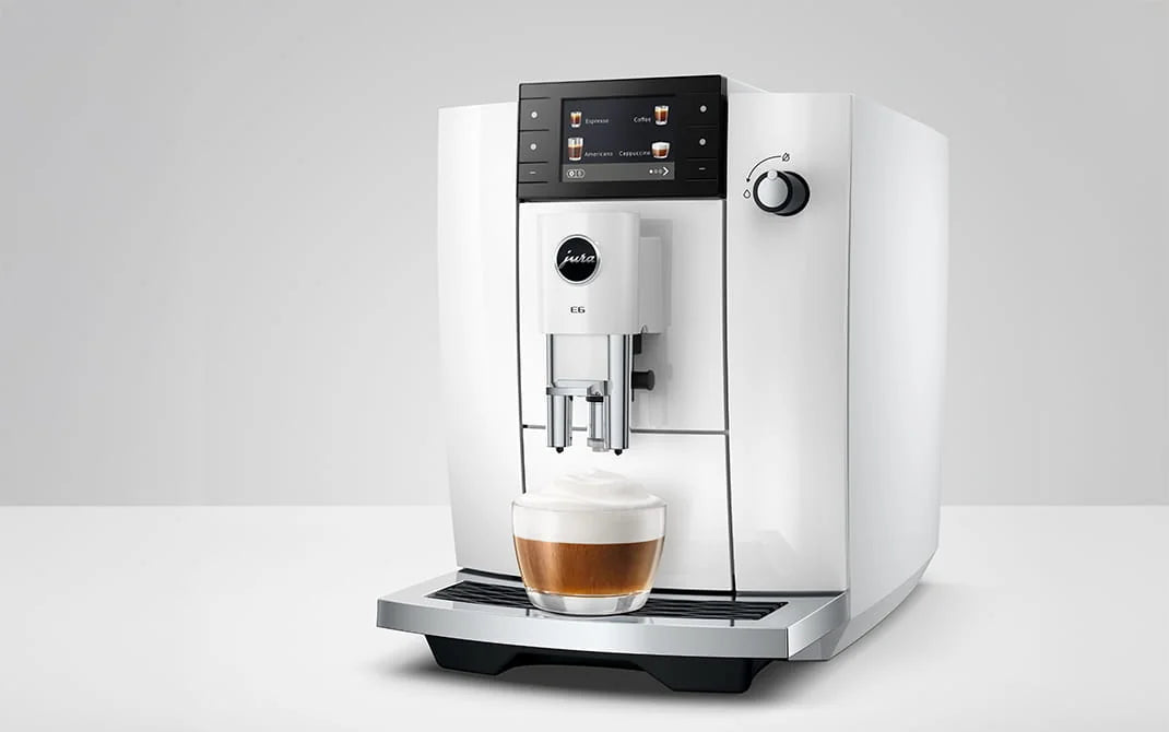 JURA E6 Piano White met cappuccino, schuin vooraanzicht