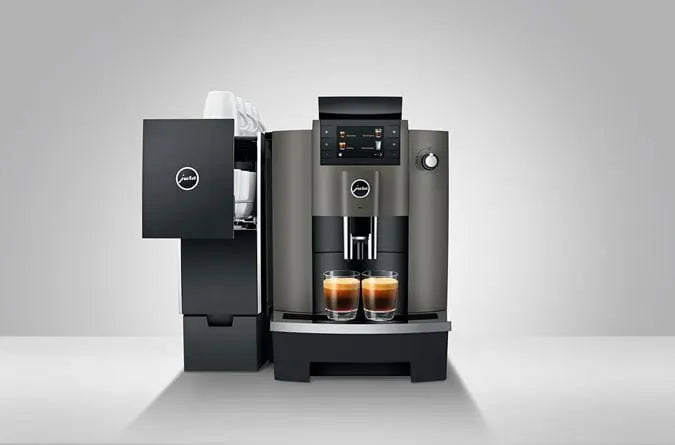 JURA W4 Dark Inox koffiemachine met twee kopjes espresso en geïntegreerde kopjeswarmer in zakelijke setting