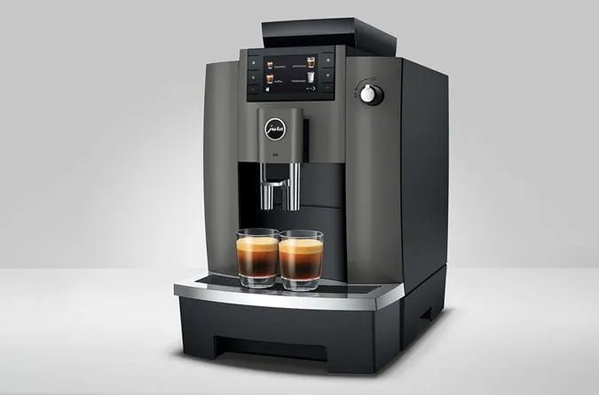 JURA W4 Dark Inox koffiemachine met twee gevulde espressoglazen en een modern display