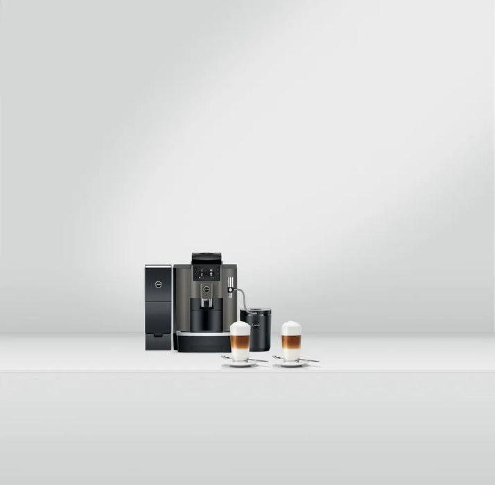 JURA W8 Dark Inox zakelijke koffiemachine met melkopschuimer en twee cappuccino's op witte achtergrond