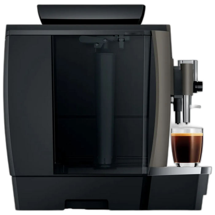 JURA W8 Dark Inox koffiemachine met een glas vers gezette koffie op de uitloop, geschikt voor zakelijk gebruik