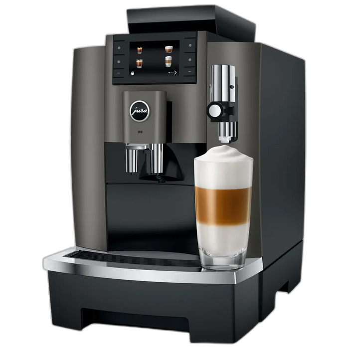 JURA W8 Dark Inox zakelijke koffiemachine met display en melkschuimer, naast een glas latte macchiato