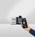 JURA X10 Dark Inox zakelijke koffiemachine met smartphonebediening en kopjesrek op de achtergrond
