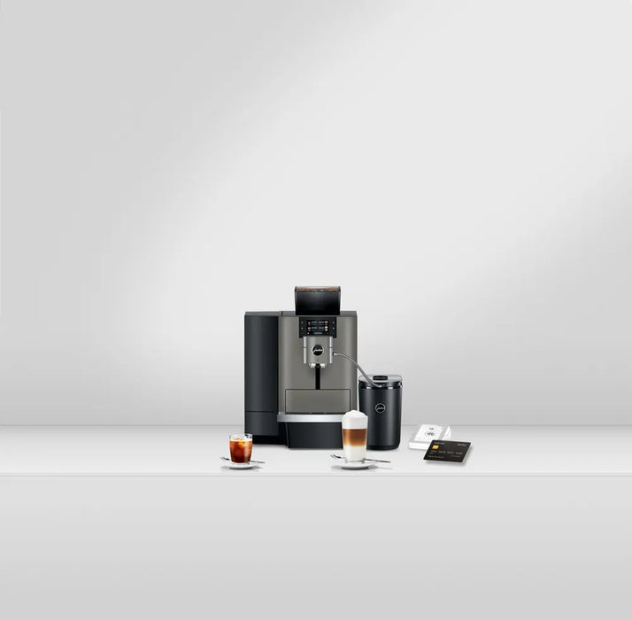 JURA X10 Dark Inox zakelijke koffiemachine met display en twee koffiespecialiteiten op tafel