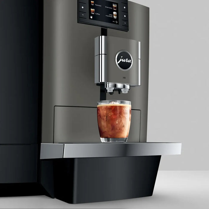 JURA X10 Dark Inox koffiemachine met Cold Brew-functie en display, in gebruik met een glas ijskoffie