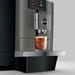 JURA X10c Dark Inox koffiemachine met glas ijskoffie op zilveren lekbak