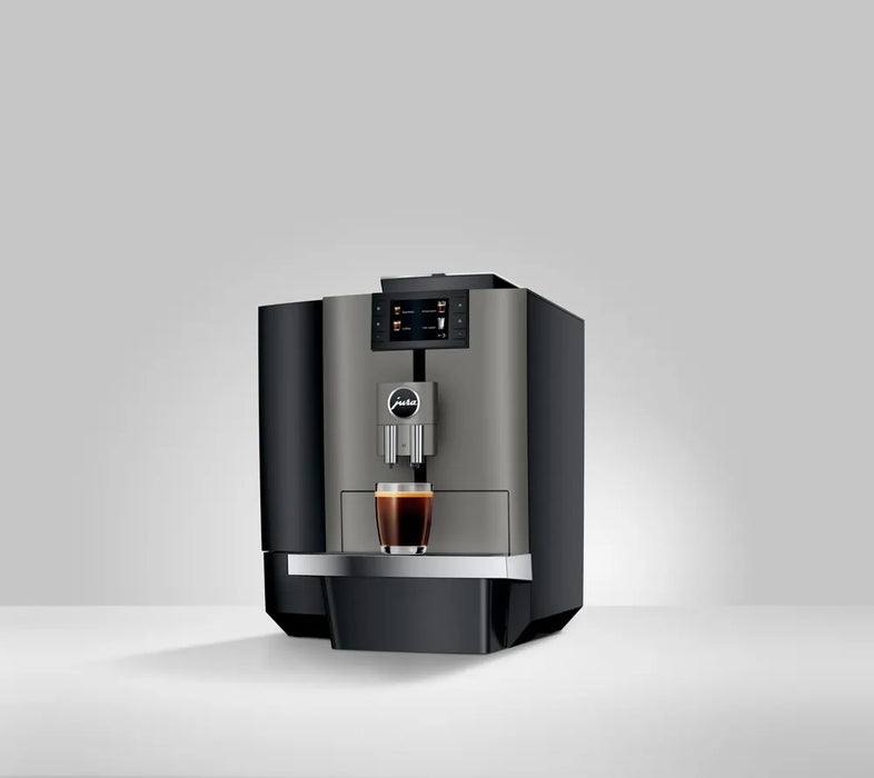 JURA X4 Dark Inox zakelijke koffiemachine met touchscreen en kopje koffie eronder