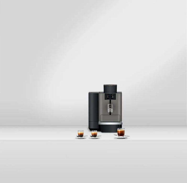 JURA X4 Dark Inox zakelijke koffiemachine met drie kopjes espresso op een rij