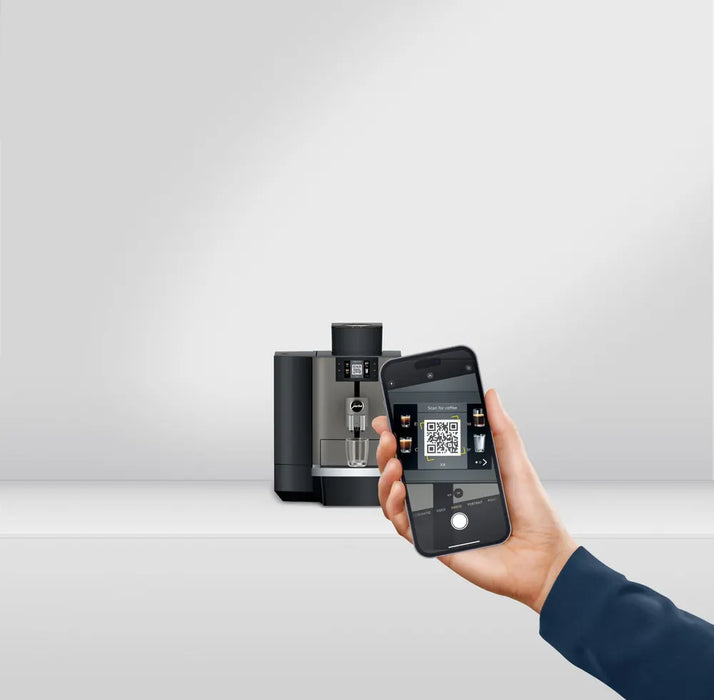 JURA X4 Dark Inox zakelijke koffiemachine met smartphonebediening in een moderne kantooromgeving